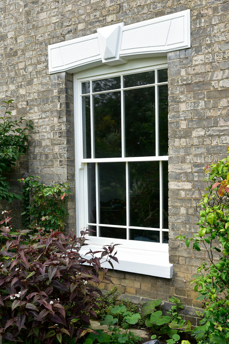 a white sash window in a traditional brick building