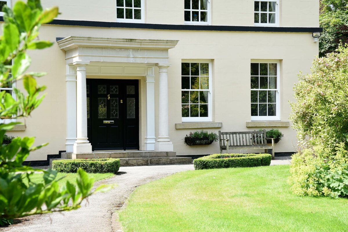 georgian sash windows and an impressive front door surrounded by stone pillars