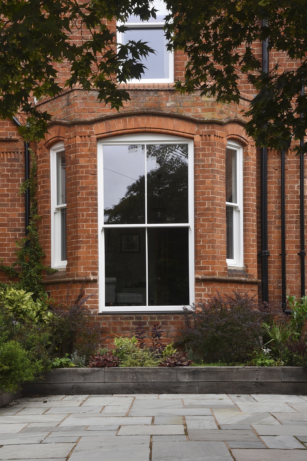 A bespoke floor level fixed sash window in ‘White’, with 18mm astragal glazing bars. Matching sash windows to either side.