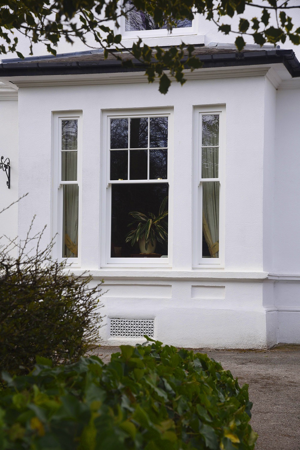 Slim sash window in ‘White’, with 18mm astragal glazing bars, manufactured in Engineered European Redwood.
