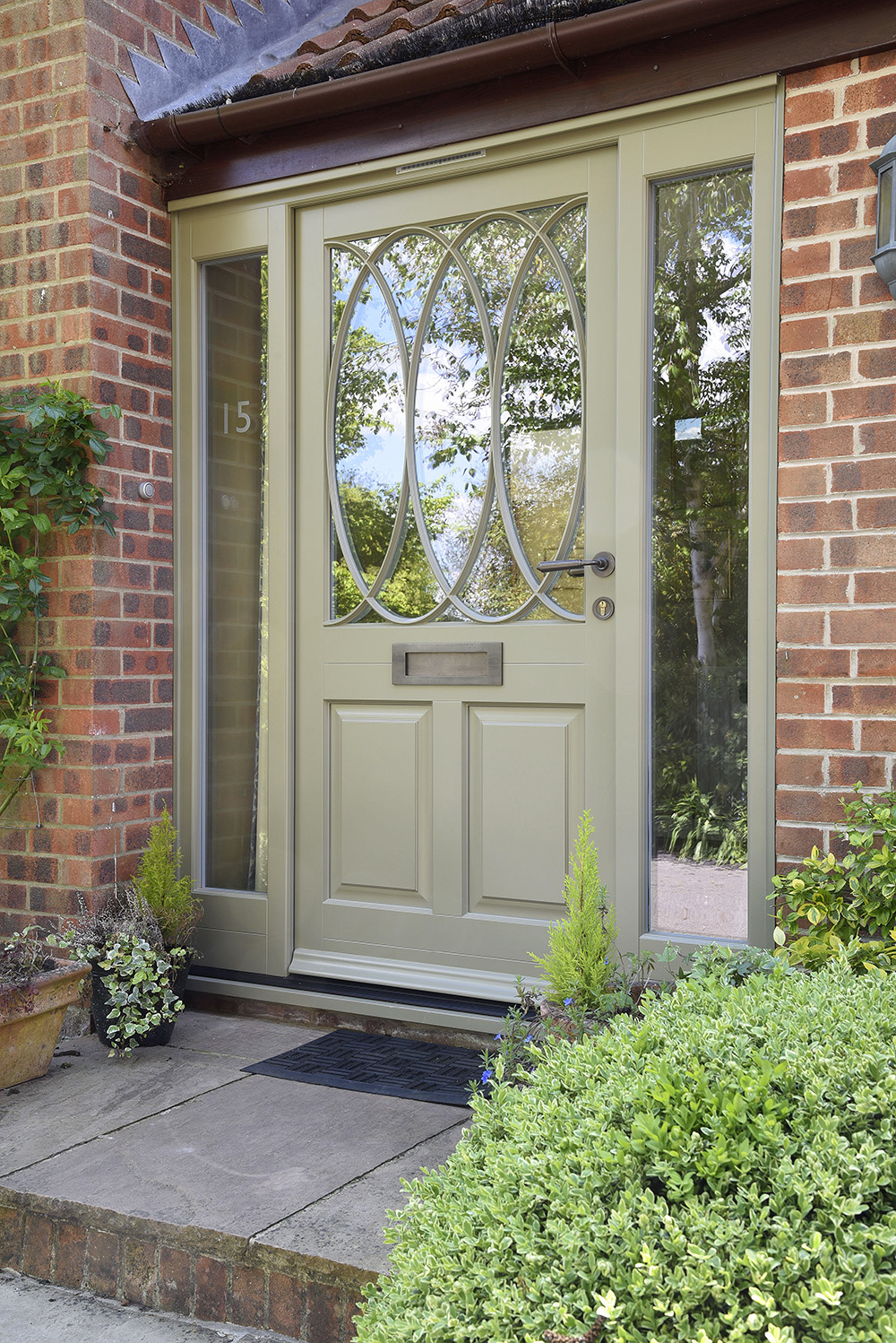 A custom Belbroughton timber entrance door with sidelights finished in ‘Oxford Clay’