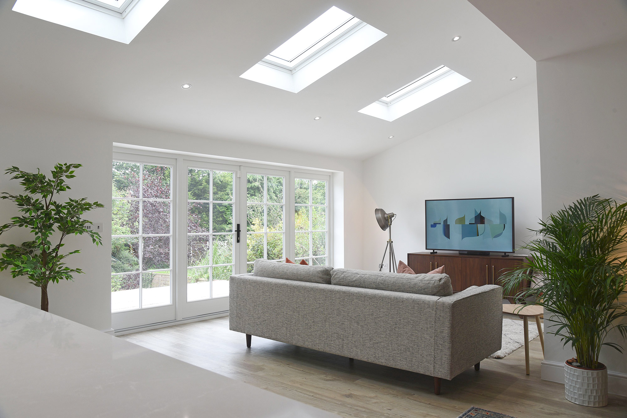 a contemporary room with a grey sofa and white french doors