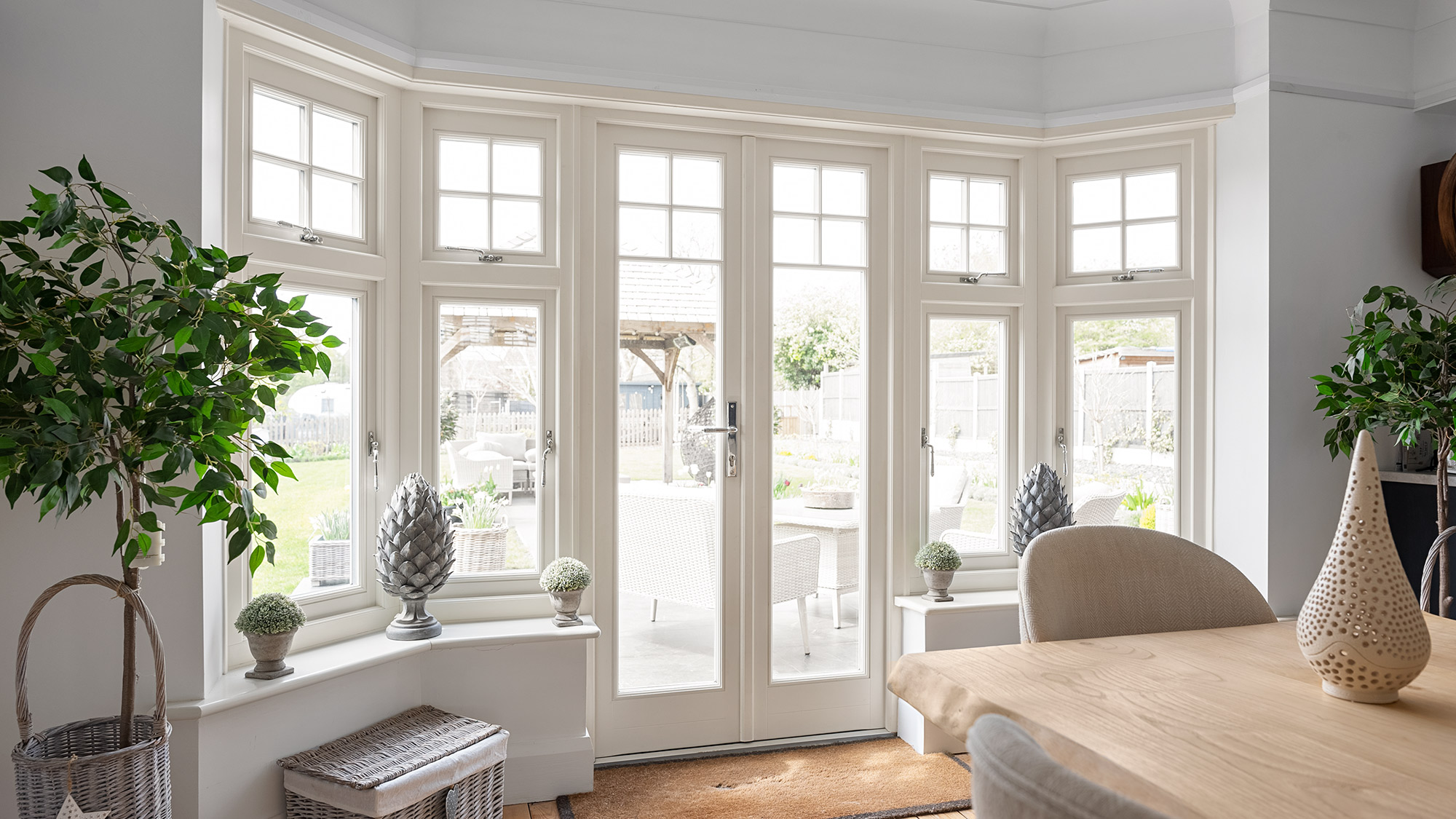 French doors with adjoining casement windows in a dining room with a wooden table