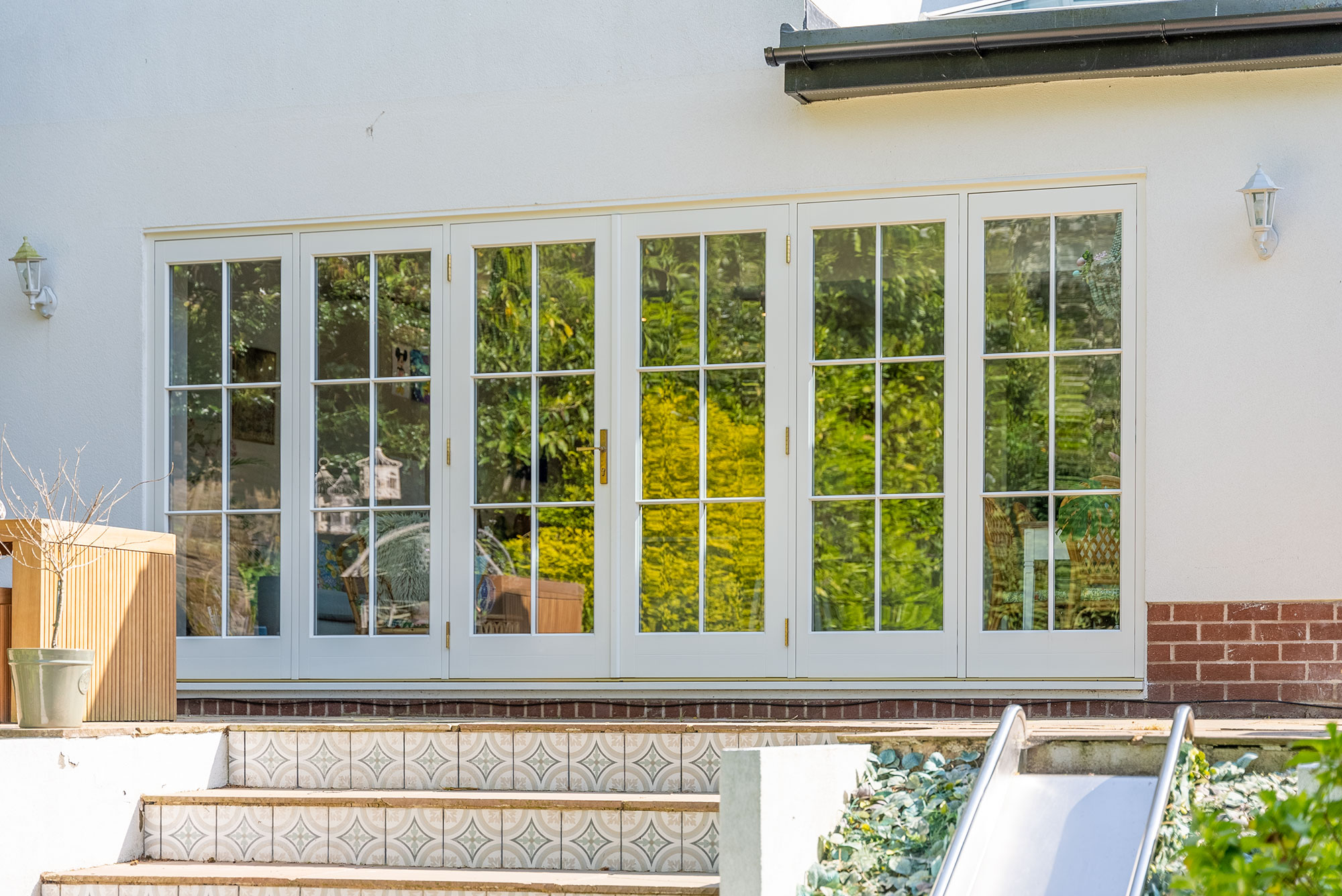 a large set of french doors with sidelights in front of a set of garden steps