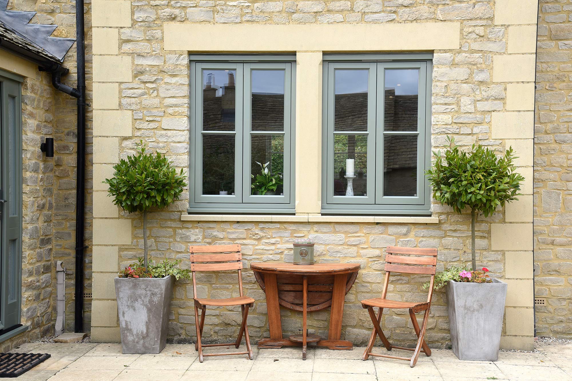 two green casement windows on a cotswold stone property